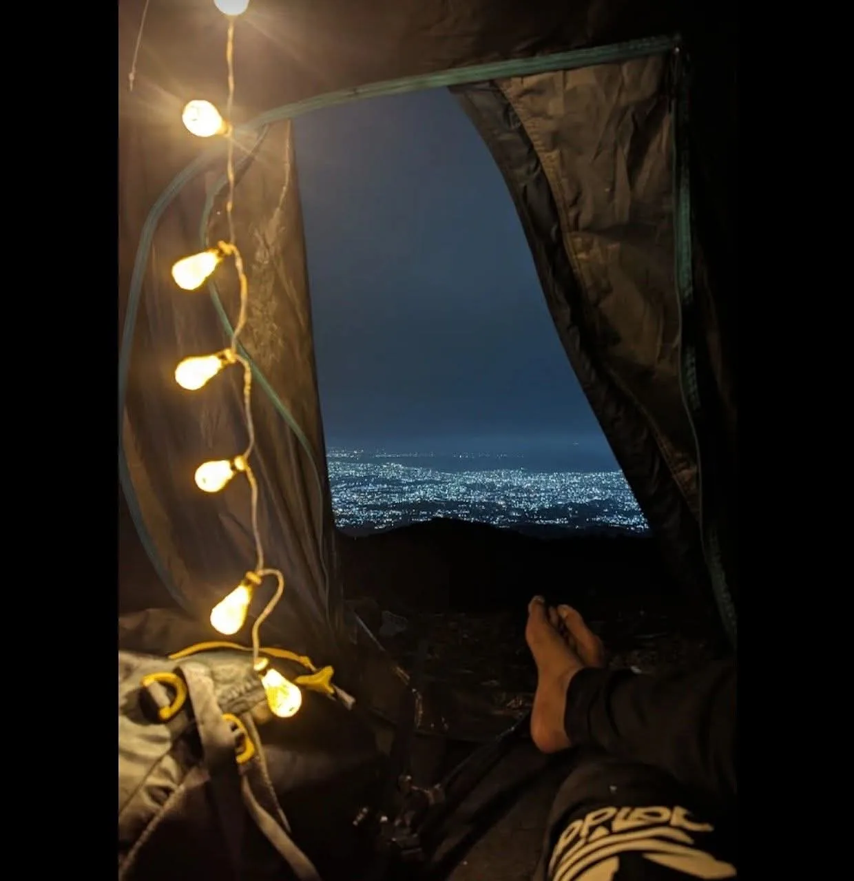 Inside tent with fairy lights and city view